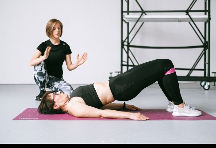 Pelvic floor physiotherapy exercise on a mat, guided by a physiotherapist
